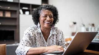 smiling person sitting in front of laptop.jpg