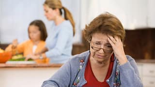 worried senior woman holding checkbook.jpg