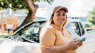 getty someone is standing by a car smiling.jpg