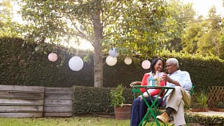 mature couple relaxing drinking wine together in their backyard.jpg