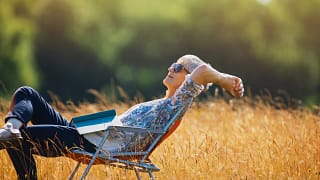 relaxed person with book on lap sitting in field.jpg