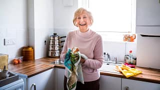 smiling person drying hands on towel in kitchen.jpg