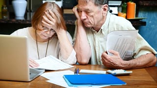 senior couple worried looking at bills finances debt.jpg
