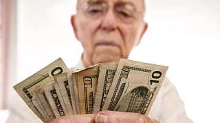 senior holding assortment cash bills social security retire getty.jpg