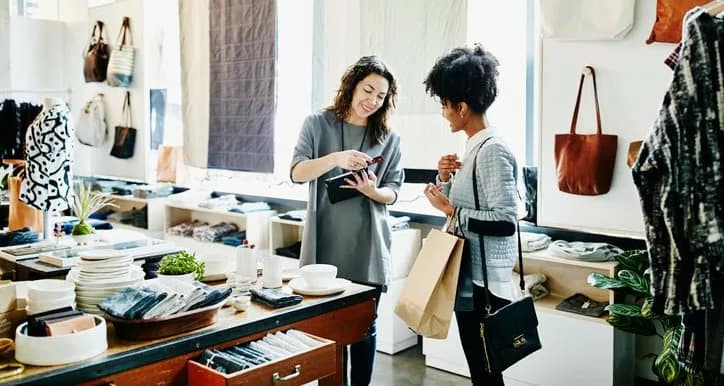 two women swiping credit card in store tjKpb.width .jpg