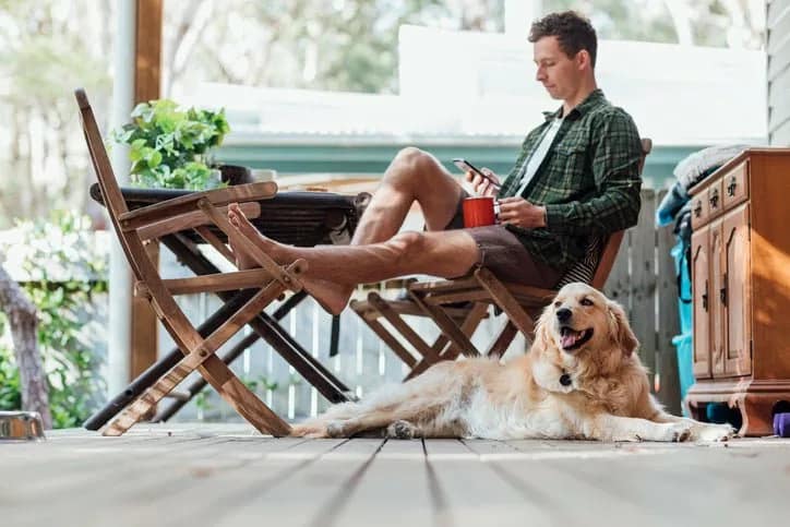 man on porch with dog phone coffee ORGJVJC.width .jpg
