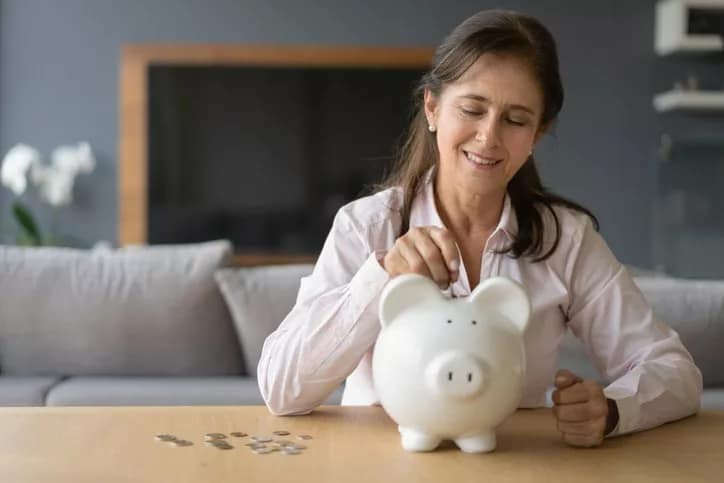 woman putting coins in piggy bank.width euqlYC.jpg