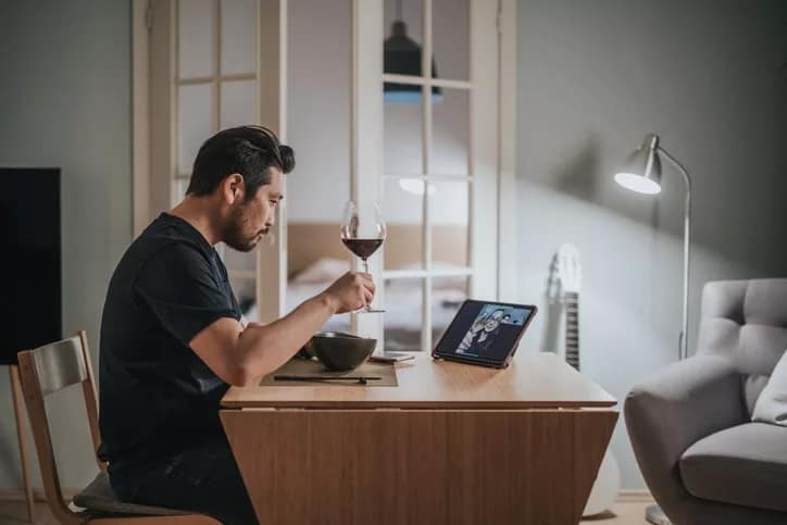 man drinking wine on video call.width .jpg