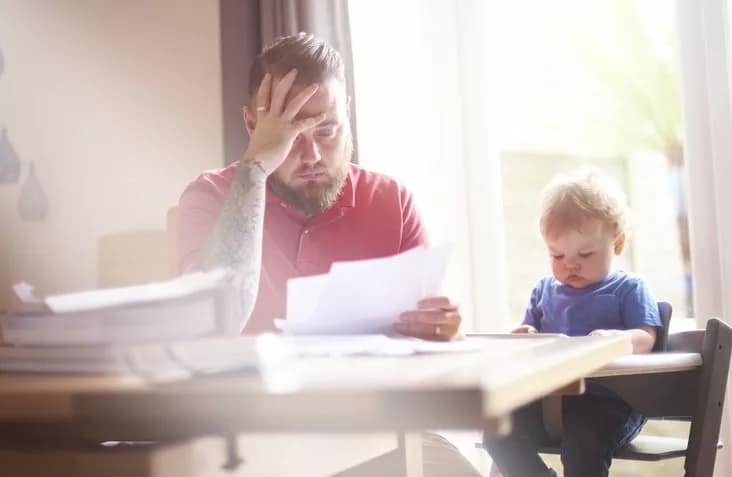 man with baby and papers at dining table.width .jpg