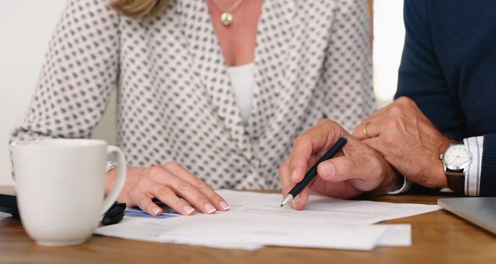 man and woman torsos signing document.jpg