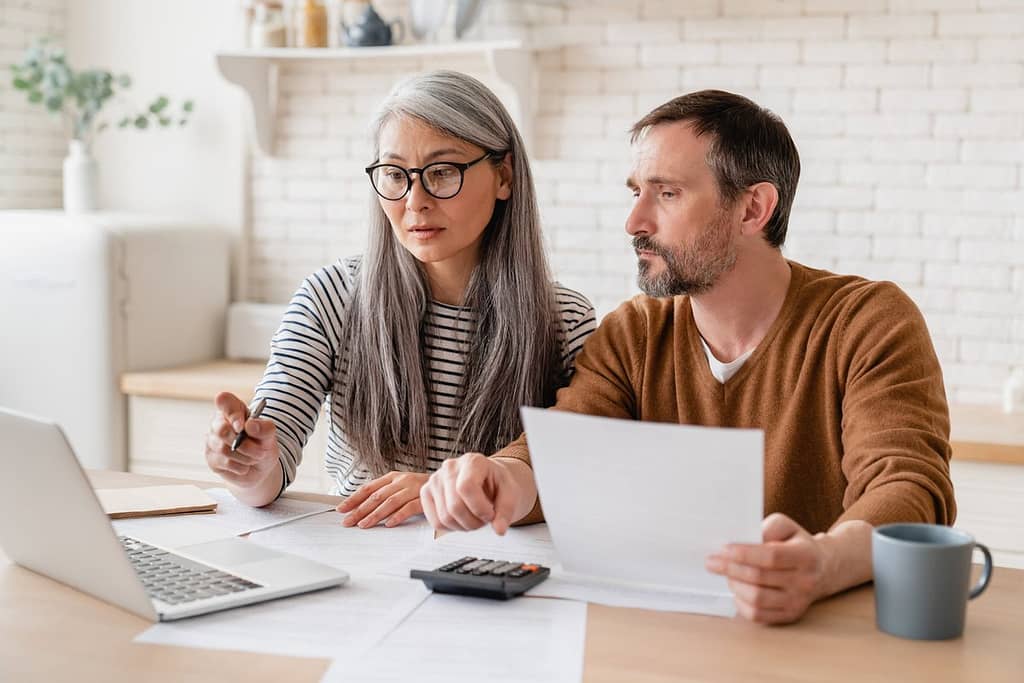 two people with bills and laptop hENMu.width .jpg