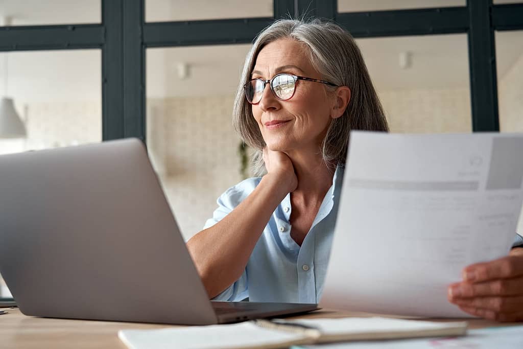 Mature woman working from laptop with documen.width ZiqNtKV.jpg