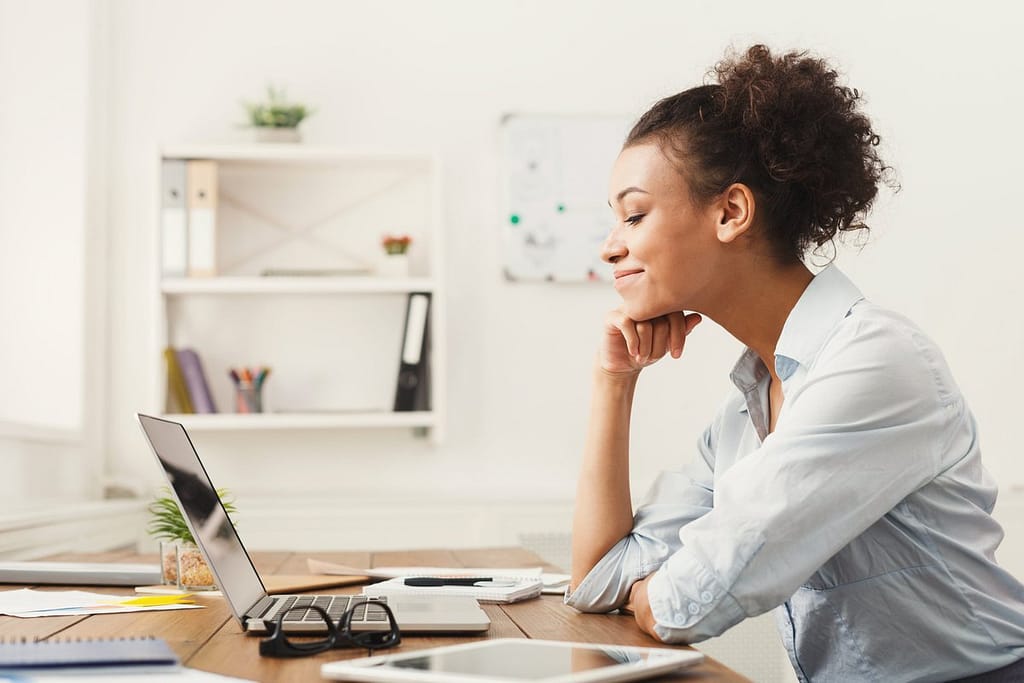 Woman smiling at office desk SulIyMb.width .jpg