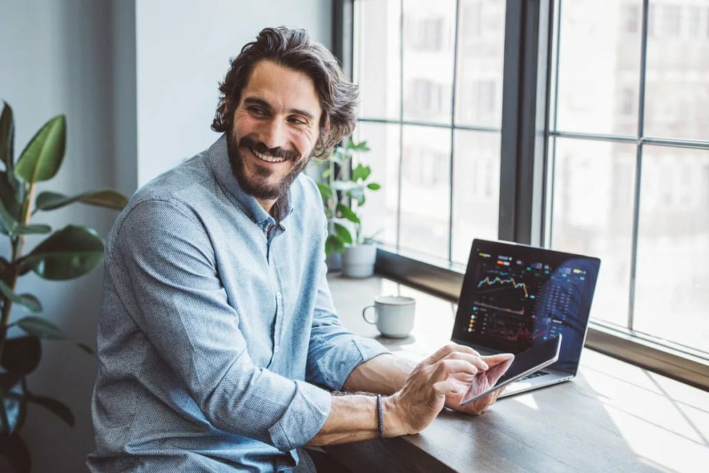 Man using laptop and cell phone to look at da.width qhRHKS.jpg