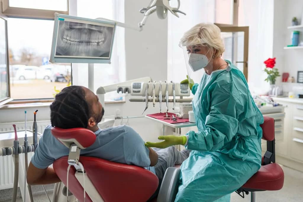 Man in chair at dentist office communicating .width .jpg