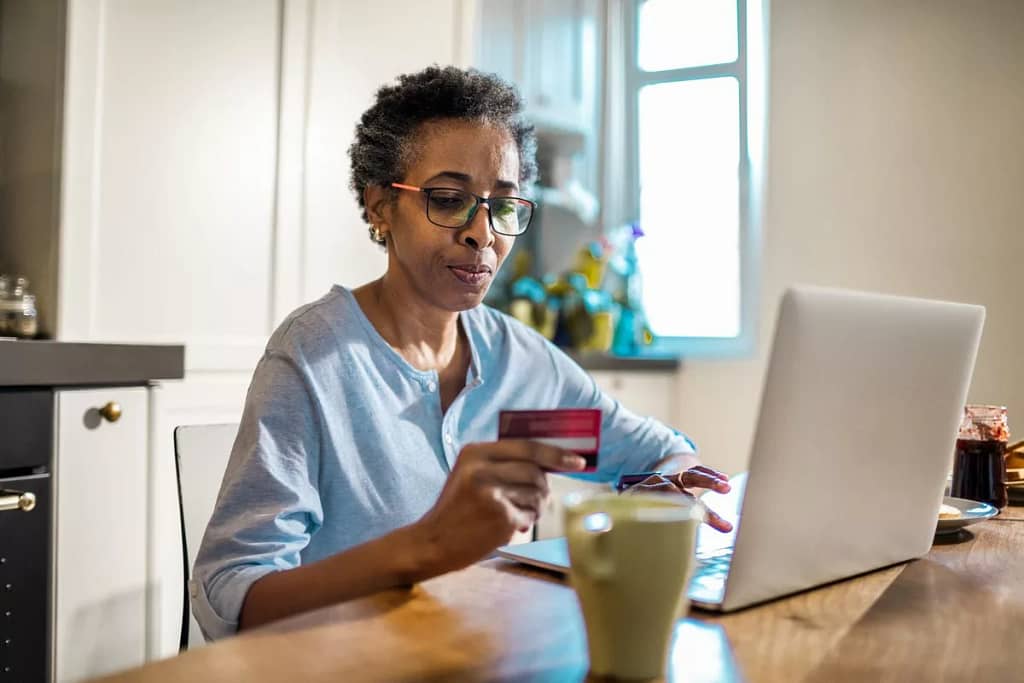 Mature woman hold credit card thoughtfully wh.width yPgZIJ.jpg
