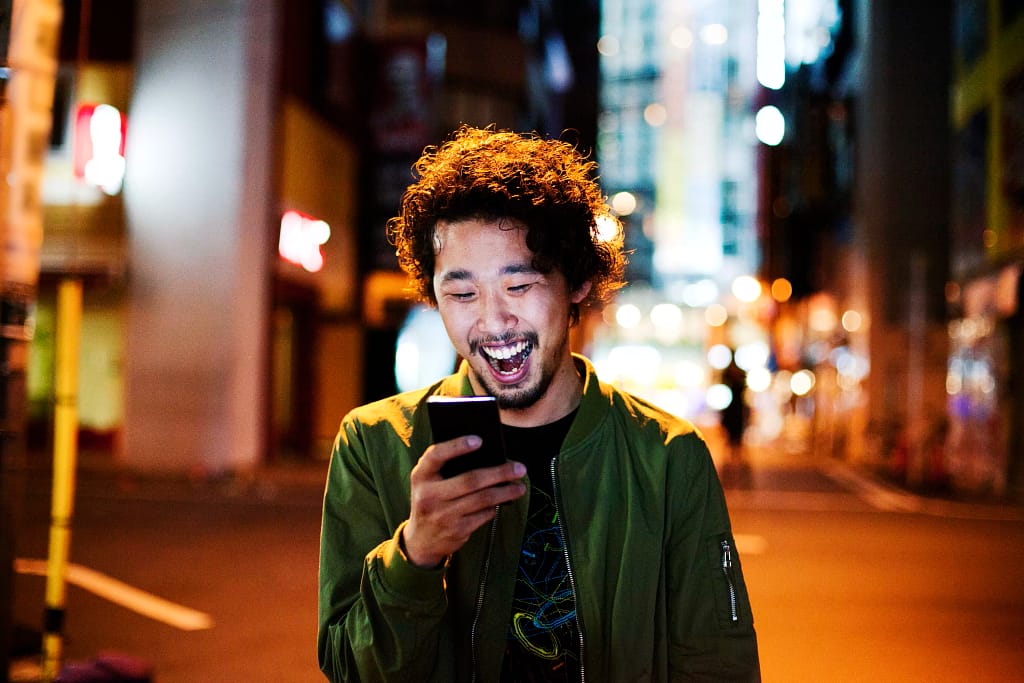 happy young man with smart phone at night.jpg