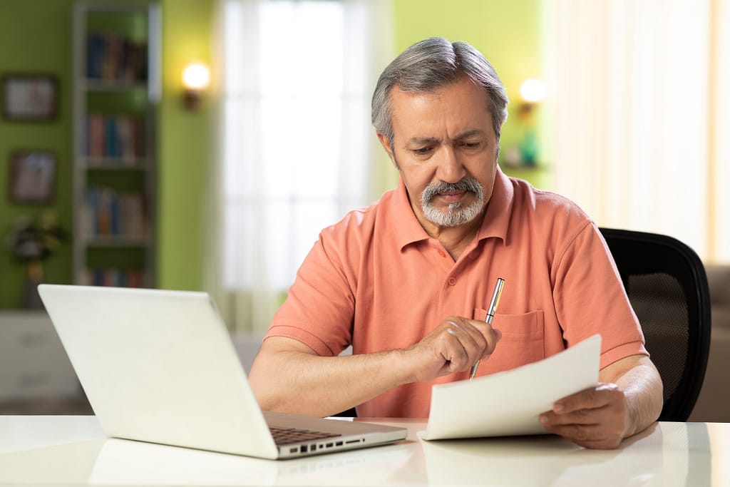mature person holding pen and looking at document.jpg