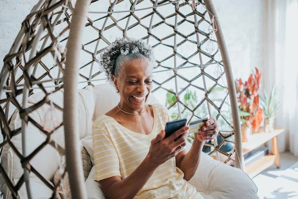 Senior woman holding a credit card and her ce.width ToyA.jpg