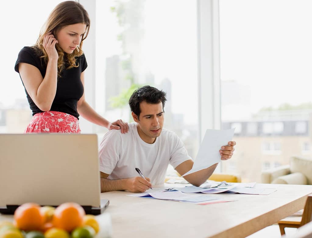 two worried people at kitchen table with bill.width MIUbkr