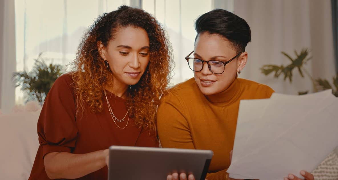 two people looking at tablet and paperwork aL.width .jpg
