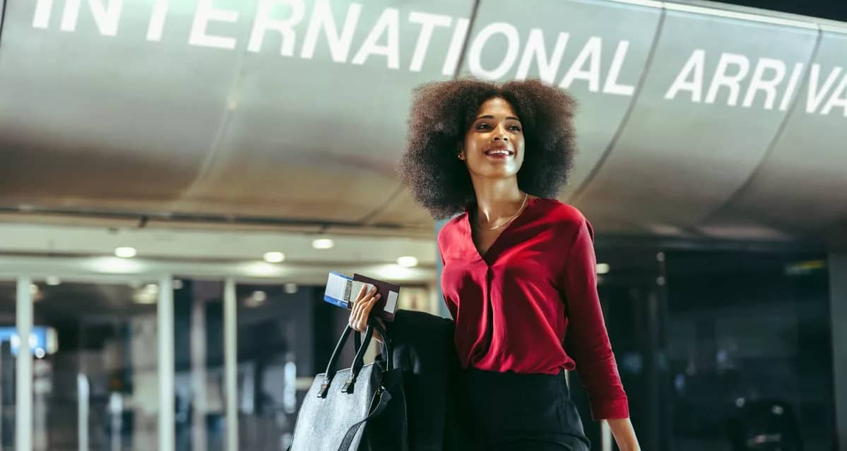 Smiling traveler walks through airport with l.width .jpg