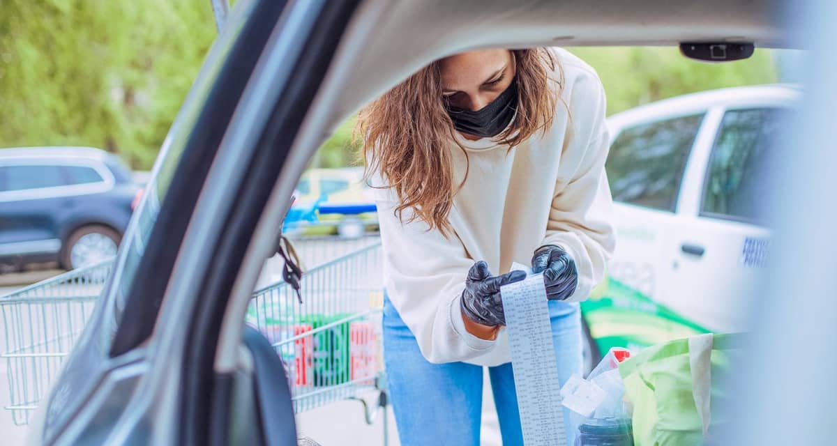 Woman loading car with groceries looks over h.width QbypC