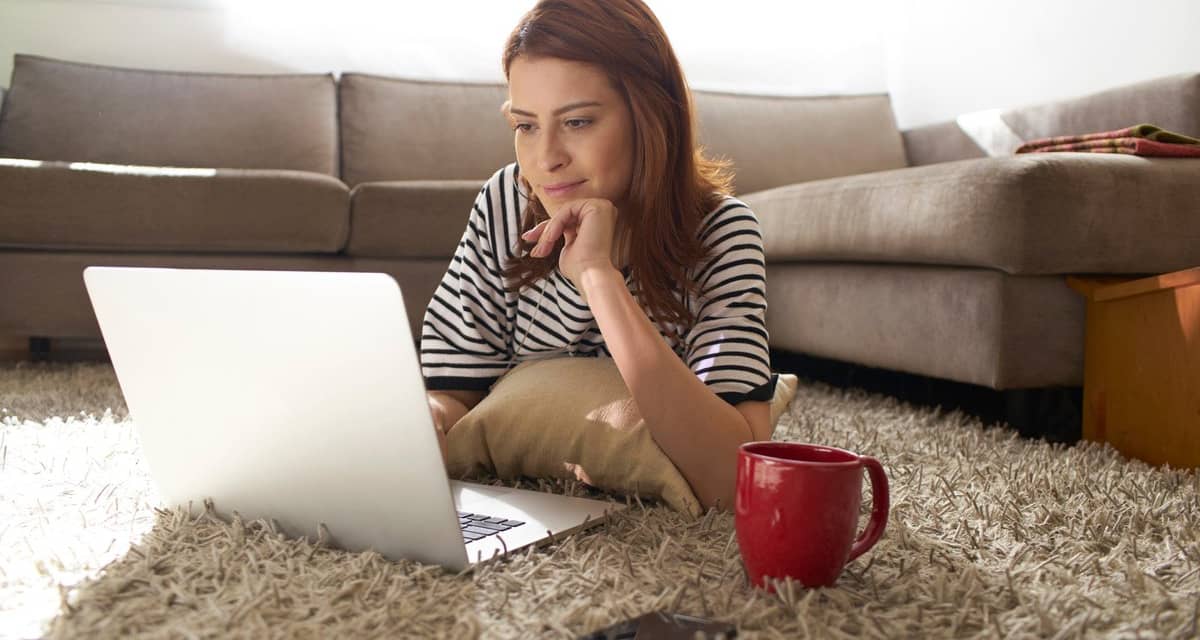 Woman using her laptop on her living room flo.width CvTcp