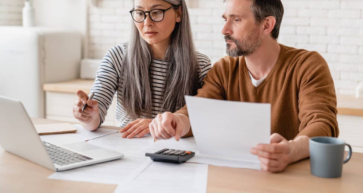 two people with bills and laptop hENMu.width .jpg