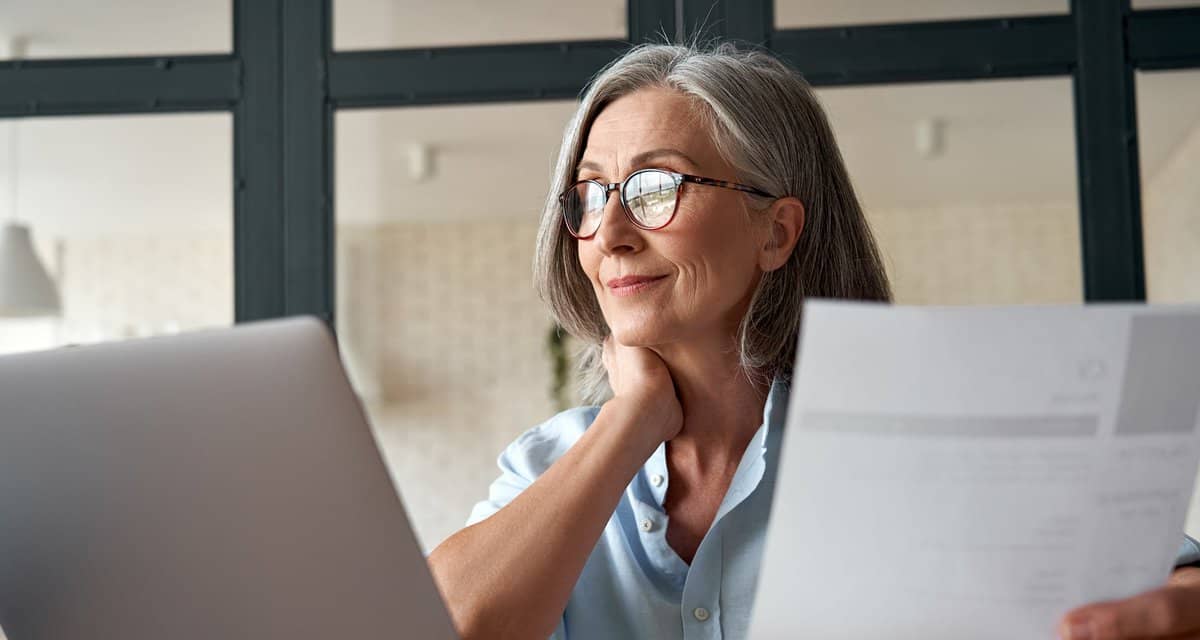 Mature woman working from laptop with documen.width ZiqNtKV.jpg