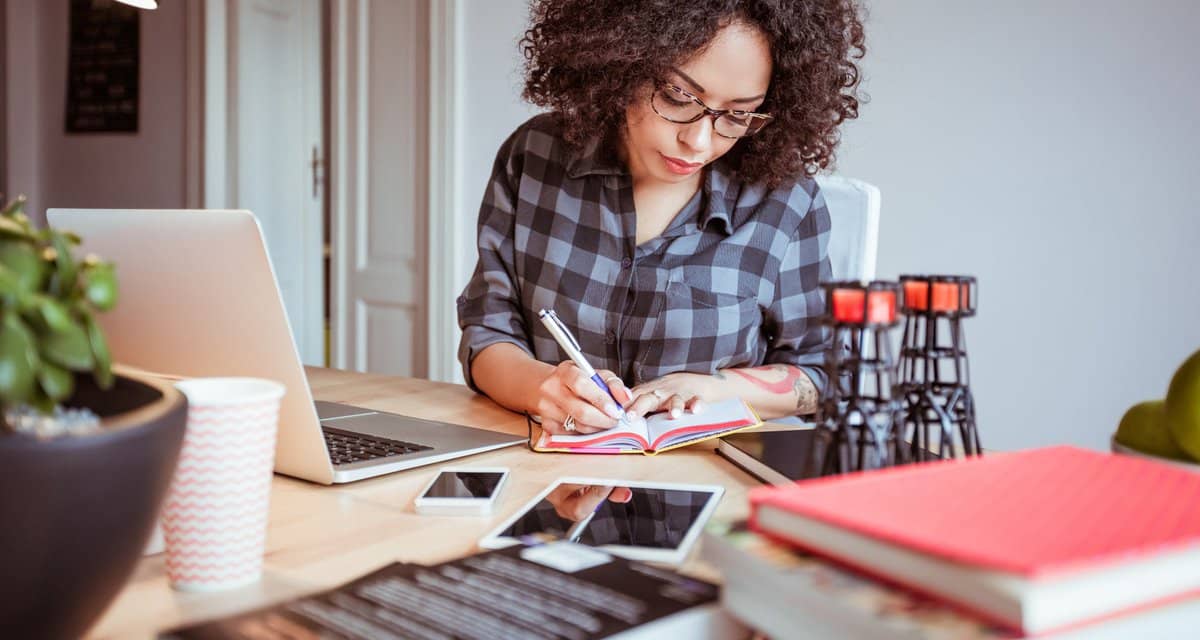 Woman taking notes while using a laptop IpOrU.width .jpg
