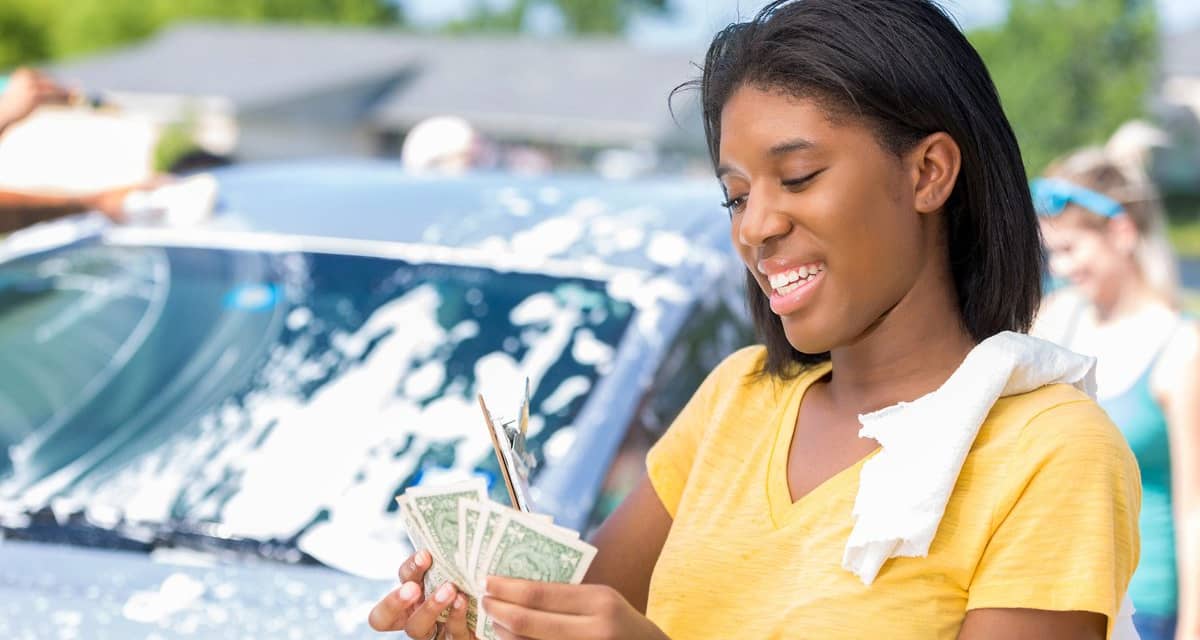 Young adult woman counts cash at car wash jbm.width .jpg