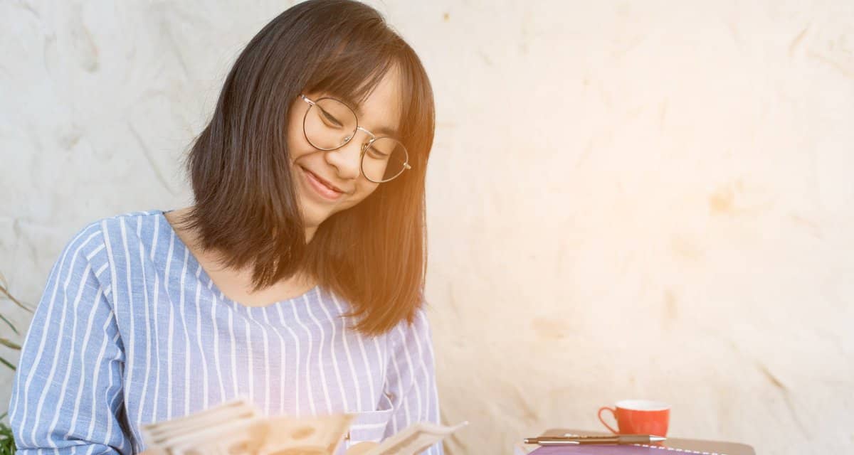 Young woman smiling as she counts cash in her.width XDyly.jpg