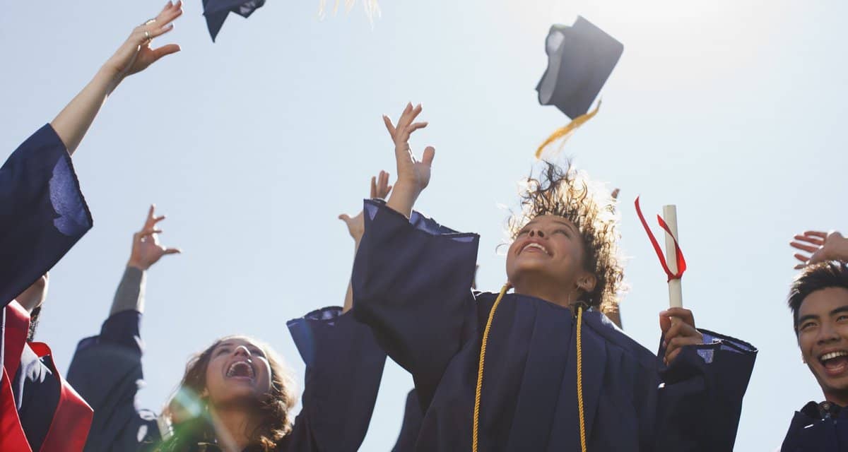 college graduates throwing mortarboards into .width mAUVTM.jpg