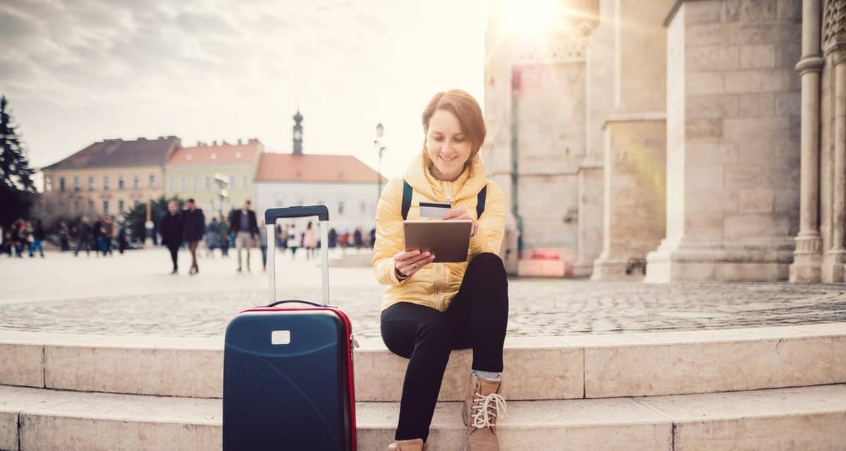 female traveler with suitcase tablet and cred.width sQbWMG.jpg