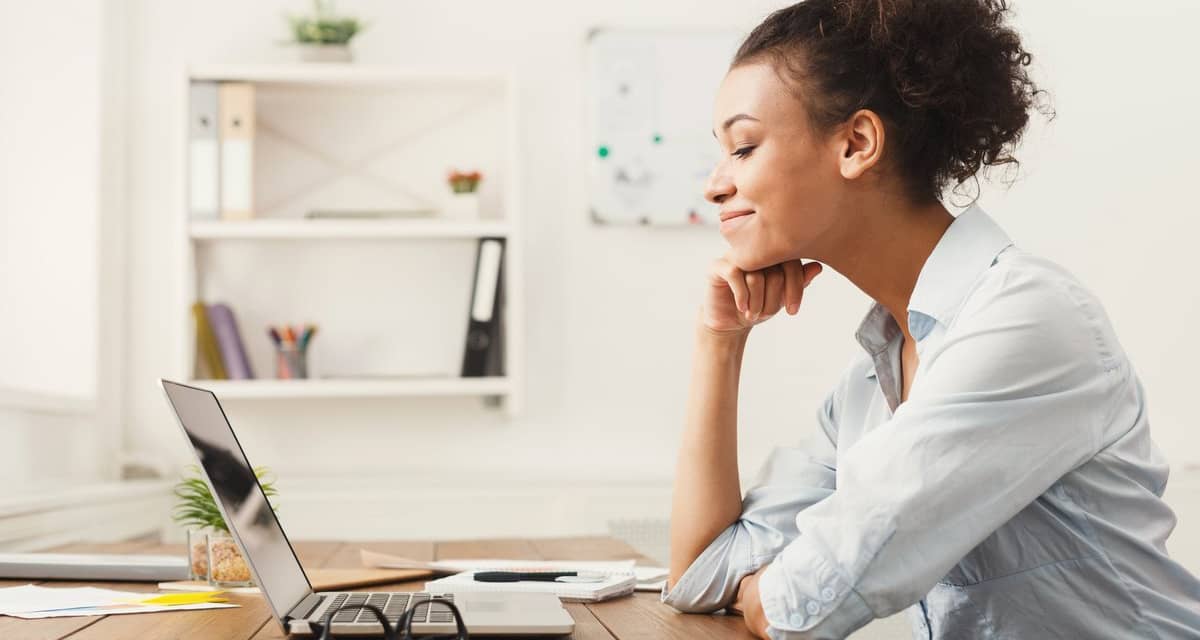 Woman smiling at office desk SulIyMb.width .jpg
