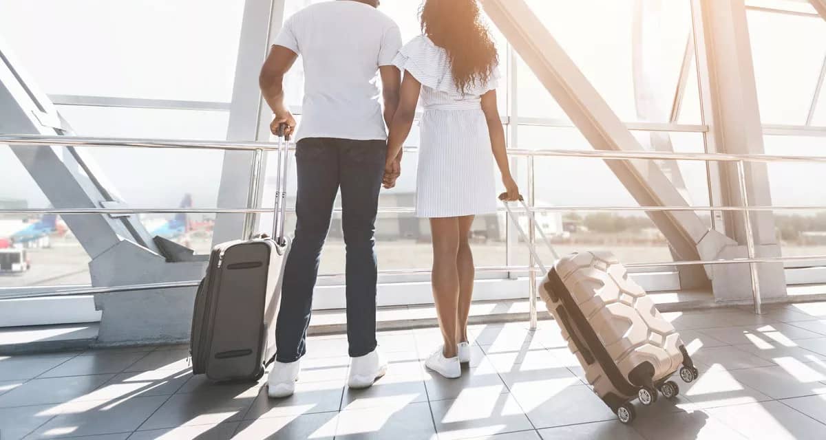 two people with suitcases holding hands hNDS.width .jpg