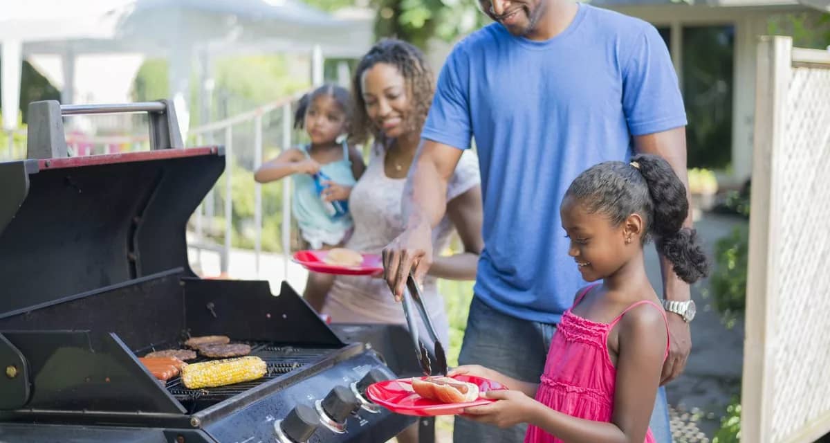 Family grilling hamburgers hotdogs and corn i.width .jpg