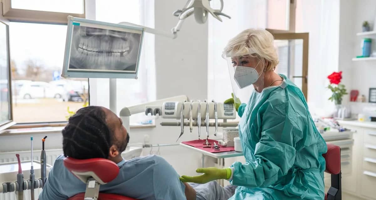 Man in chair at dentist office communicating .width .jpg