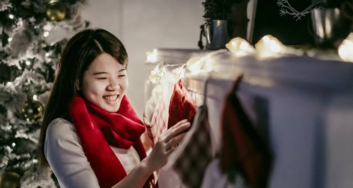 Woman hanging Christmas stocking over firepla.width .jpg