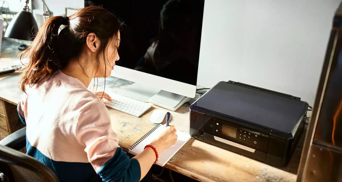 Woman writing in notebook at her home desk U.width .jpg