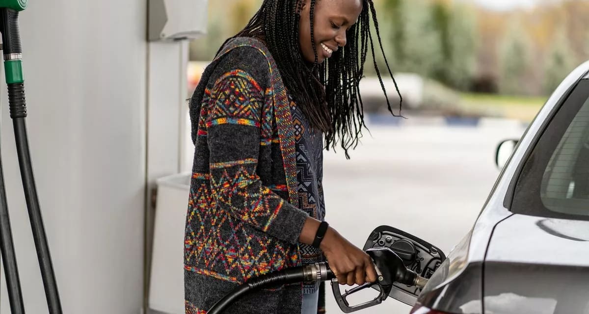 Person smiling while pumping fuel into vehicl.width .jpg