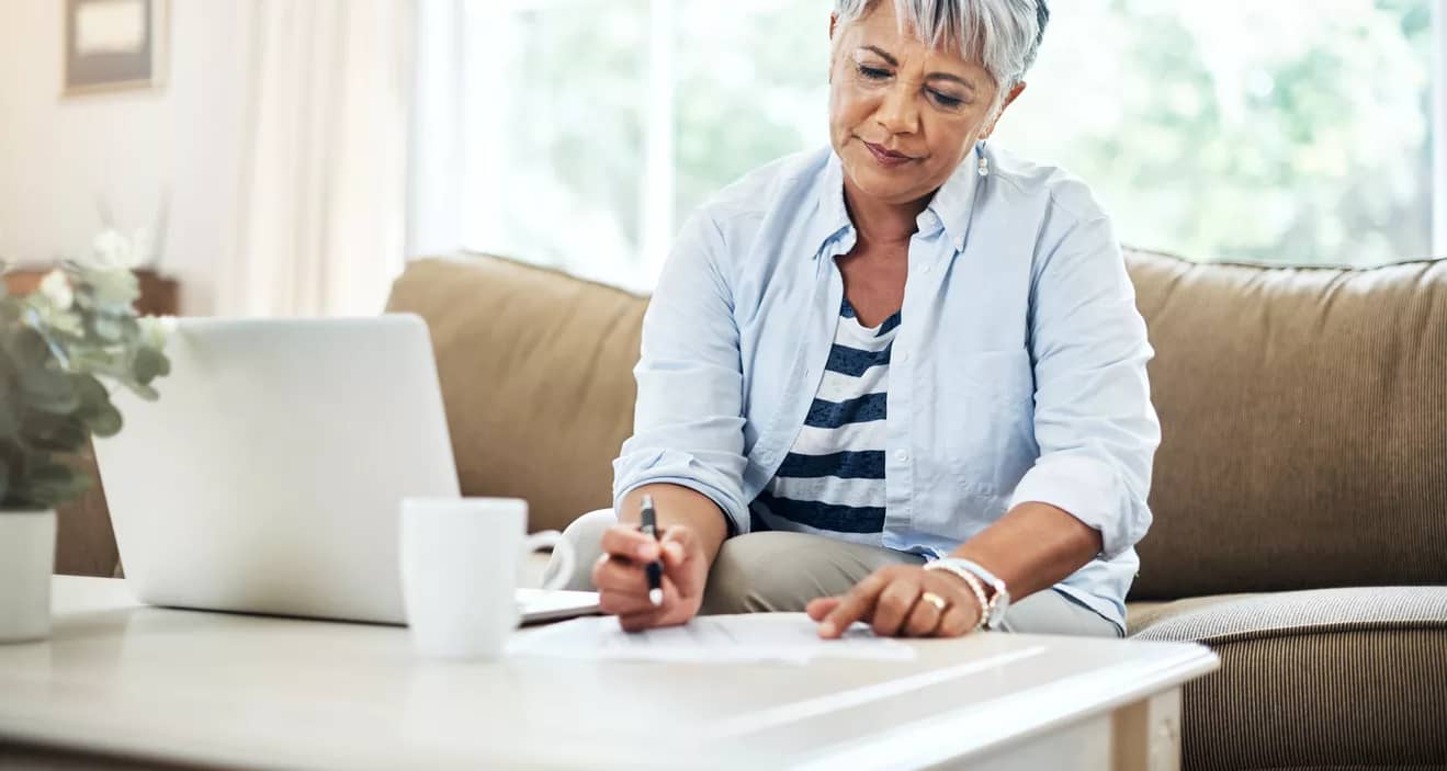 person holding pen and looking at document on coffee table.jpg