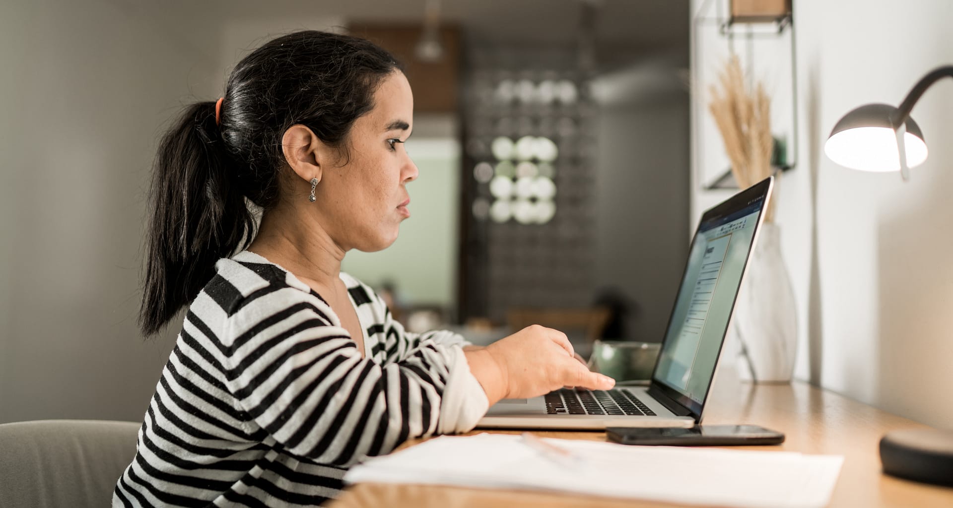 person sitting at desk and typing on laptop