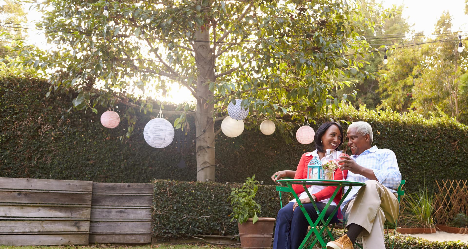 mature couple relaxing drinking wine together in their backyard
