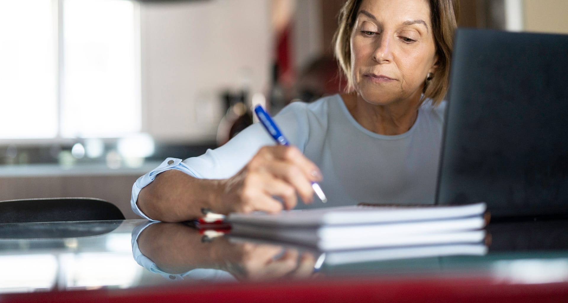 older woman taking notes laptop gettyimages