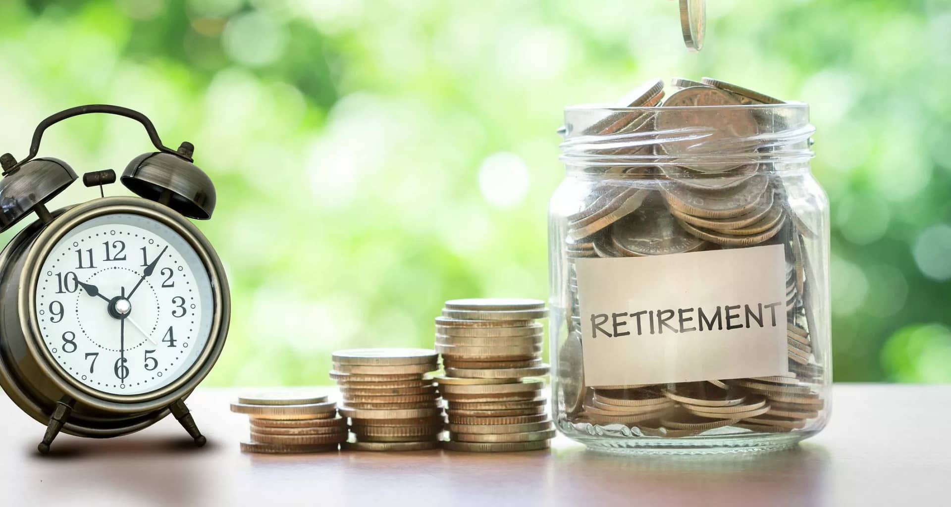 retirement savings jar full of coins and alarm clock .jpg