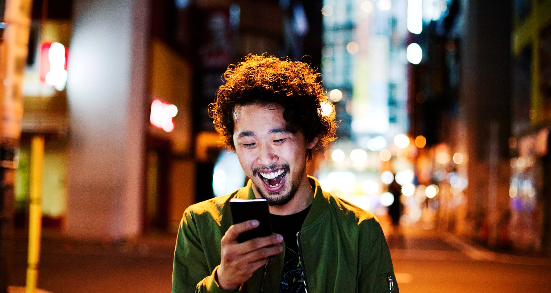 happy young man with smart phone at night.jpg