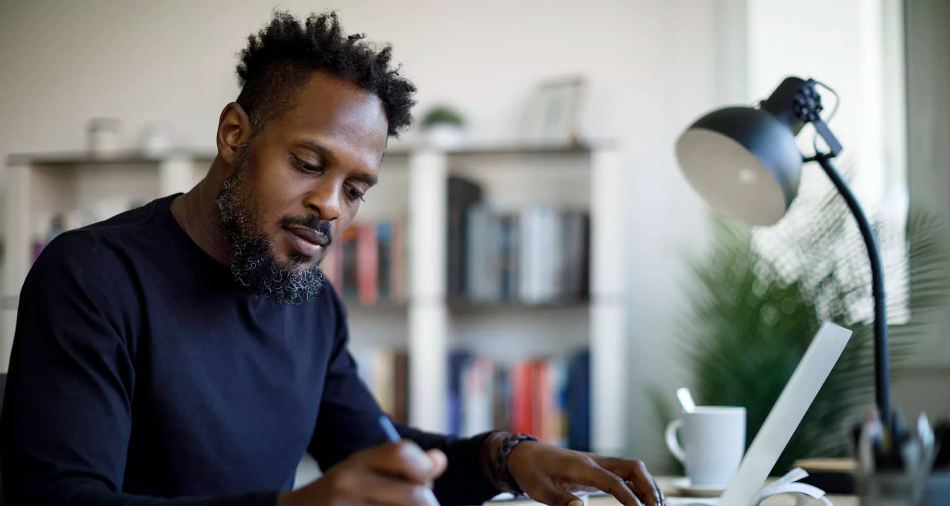 person sitting at a desk looking at a laptop and documents.jpg