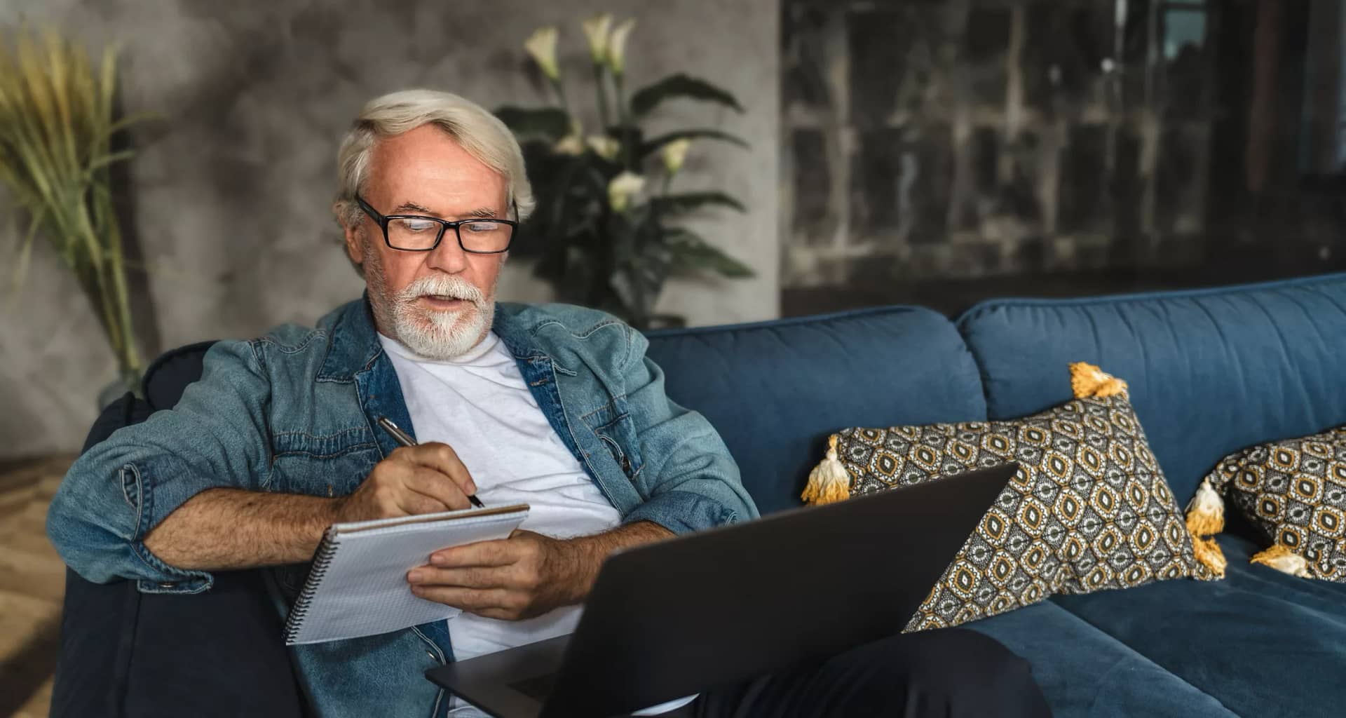 senior holding laptop and writing note in notebook.jpg